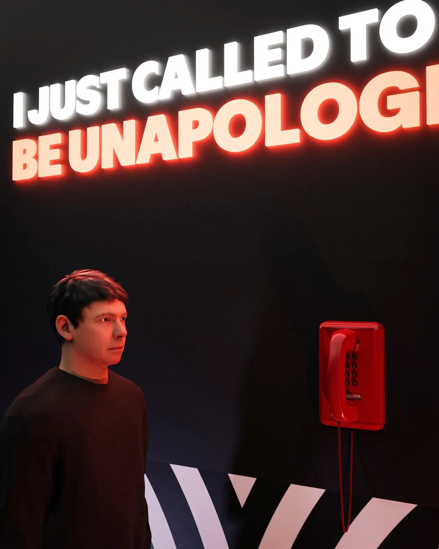 A figure beside a red telephone under the words I just called to be unapologetic.